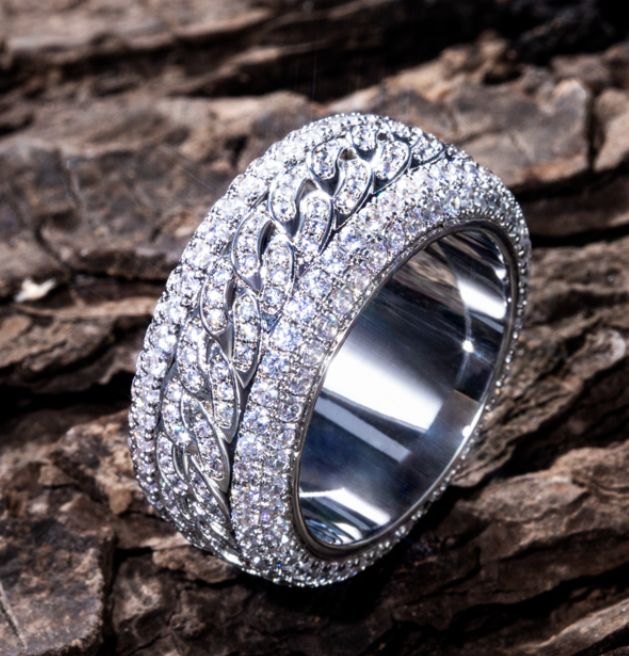 Silver ring with intricate design on a wooden surface